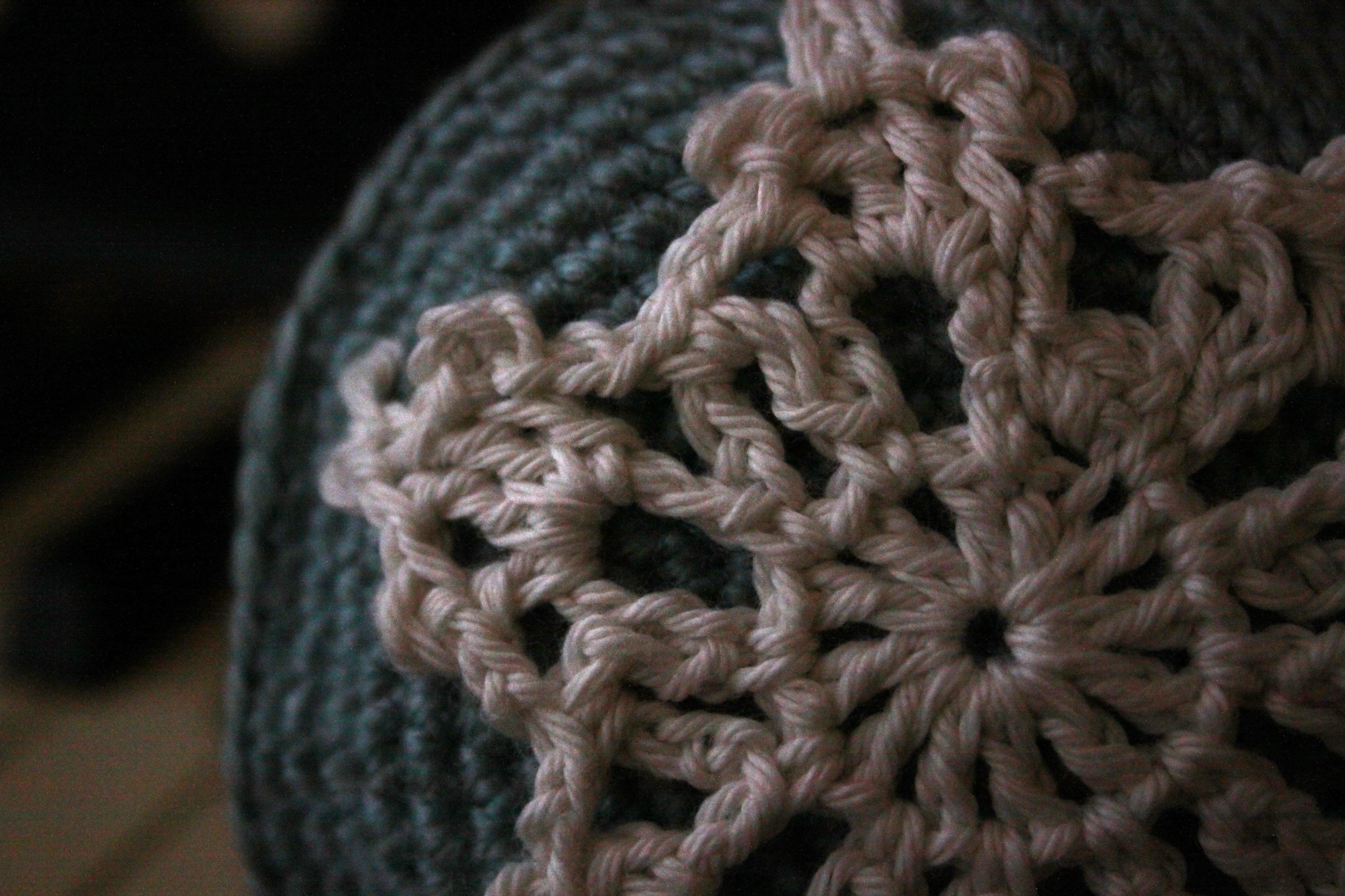 A white crochet creature lit by candlelight